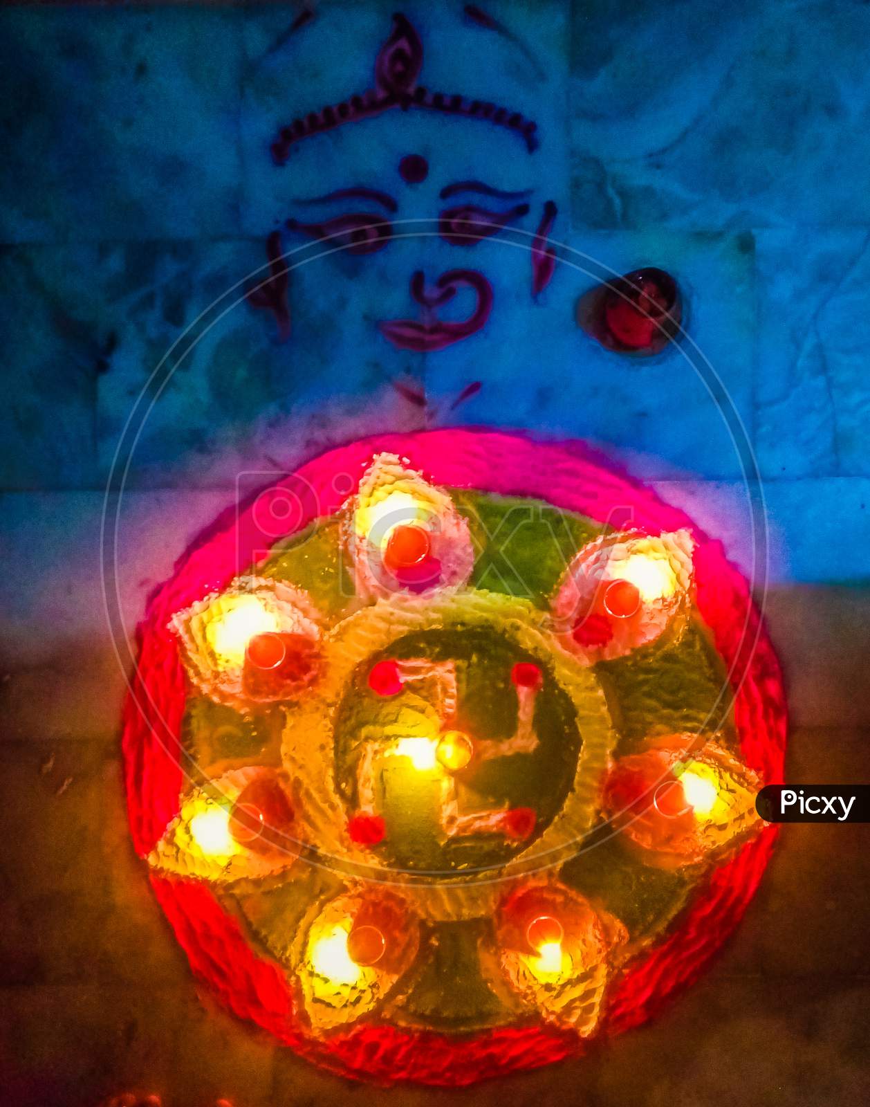 Rangoli with colours and earthen lamps on Diwali celebration along with Laxmi mata symbol drawn sidewise.