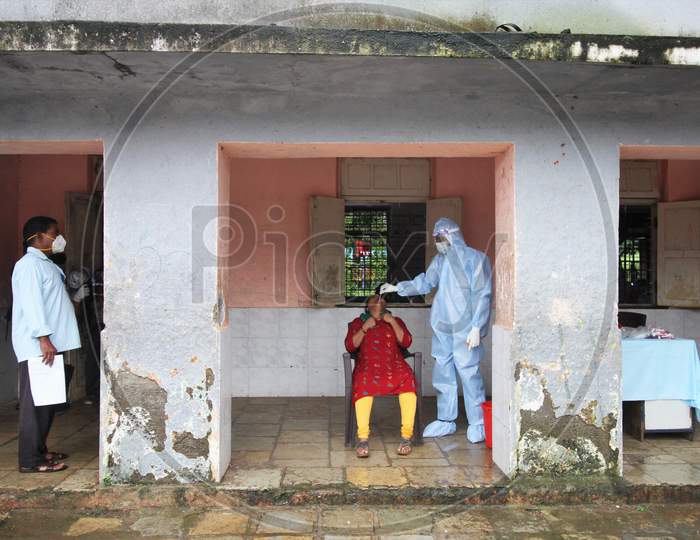 A healthcare worker wearing personal protective equipment (PPE) collects a swab sample from a person during a check-up campaign for the coronavirus disease (COVID-19), in Mumbai, India on July 28, 2020.
