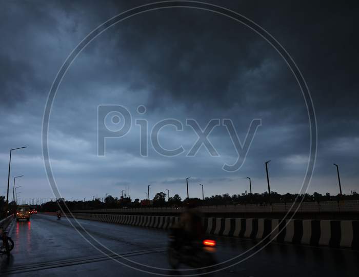 People drive through a street as an overcast sky is seen on the outskirts of Jammu on July 29, 2020.