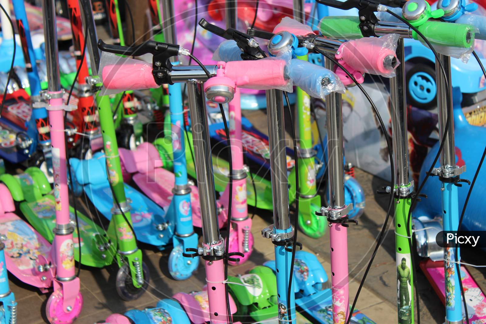 Cropped image of colorful children's scooter handles, and blurred children scooter at background, at Esplanade, Kolkata.