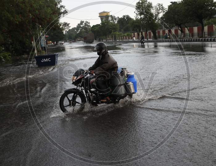 A man rides his bike through a water-logged street during rains on the outskirts of Jammu on July 29, 2020.