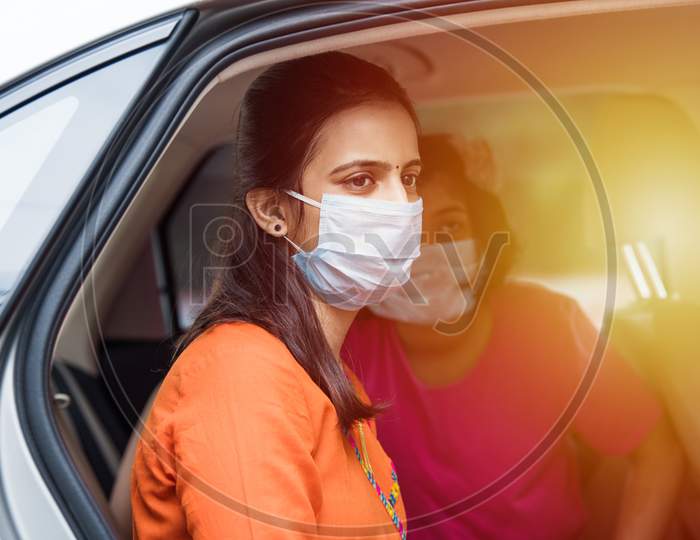 Indian Young Mother And Daughter Wearing Face Mask While Driving Car