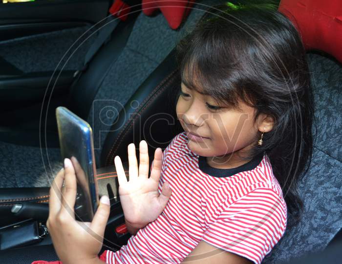 Asian Little Girl Make Video Call Using A Cellphone In The Car