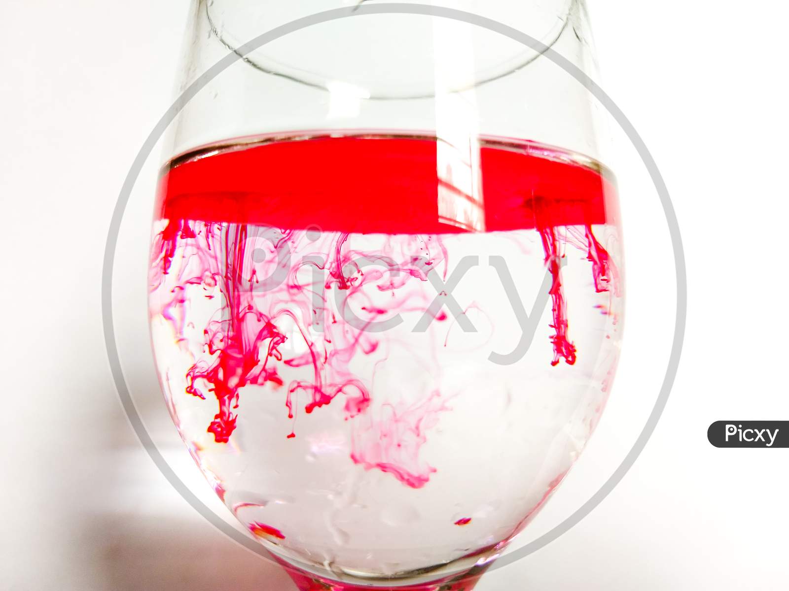 Red ink in a glass of water.