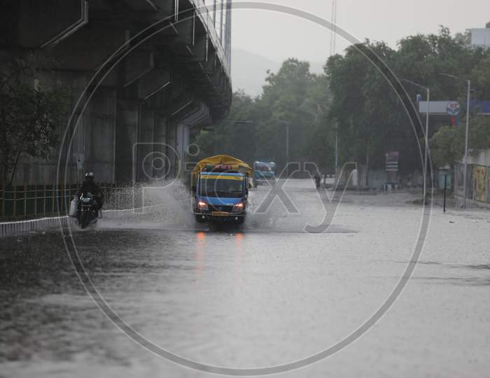 People drive through a street during rains on the outskirts of Jammu on July 29, 2020.
