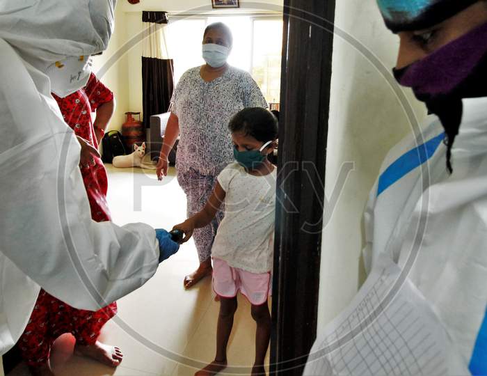 Healthcare workers wearing personal protective equipment (PPE) measure the pulse of a girl during a check-up campaign for the coronavirus disease (COVID-19), in Mumbai, India on July 26, 2020.