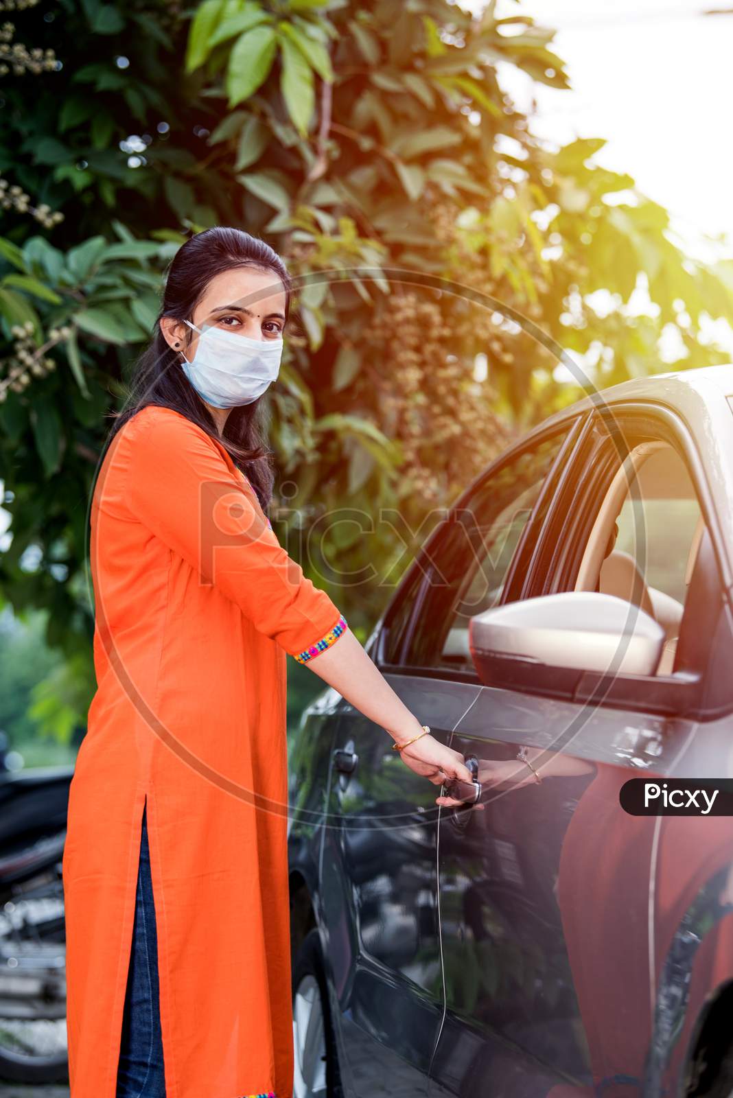 Indian Young Woman Or Girl Wearing Face Mask While Driving Car