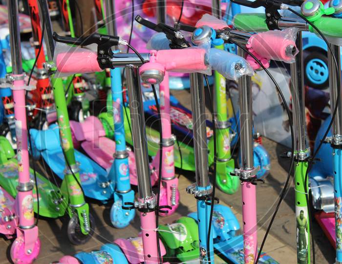 Cropped image of colorful children's scooter handles, and blurred children scooter at background, at Esplanade, Kolkata.