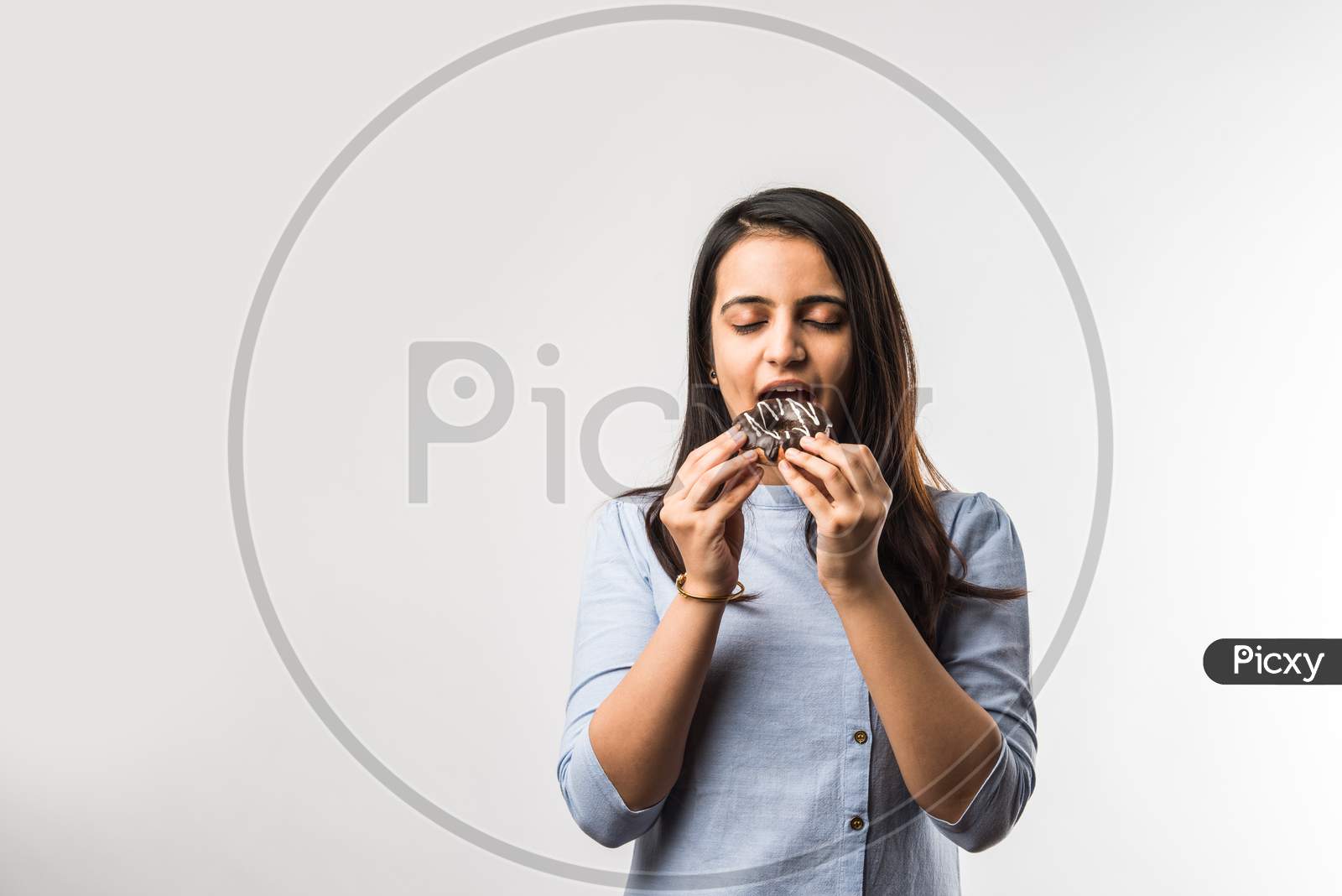 Indian Girl Eating Chocolate Donut, Isolated Over White Background