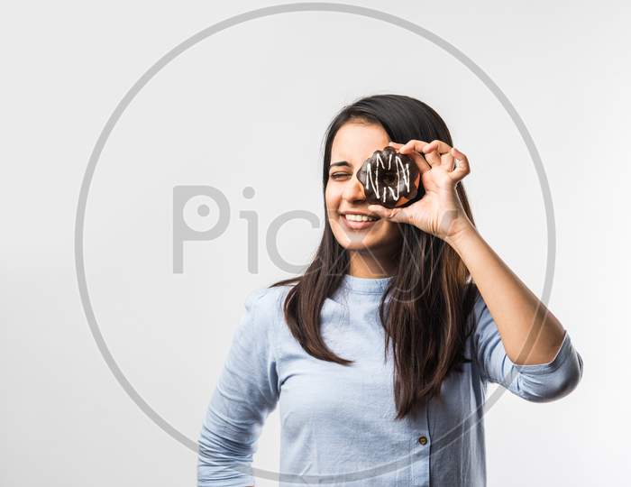 Indian Girl Eating Chocolate Donut, Isolated Over White Background