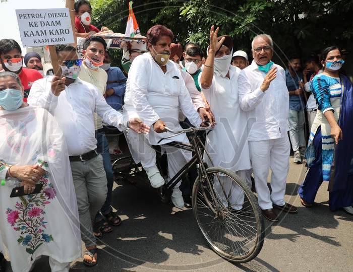 Senior Congress leader and former minister Raman Bhalla along with his party workers ride a bicycle rickshaw to protest the hike in the prices of petrol and diesel in Jammu on July 03, 2020.