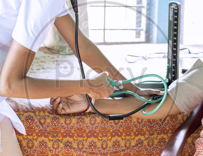 a nurse/doctor measuring blood pressure of a patient