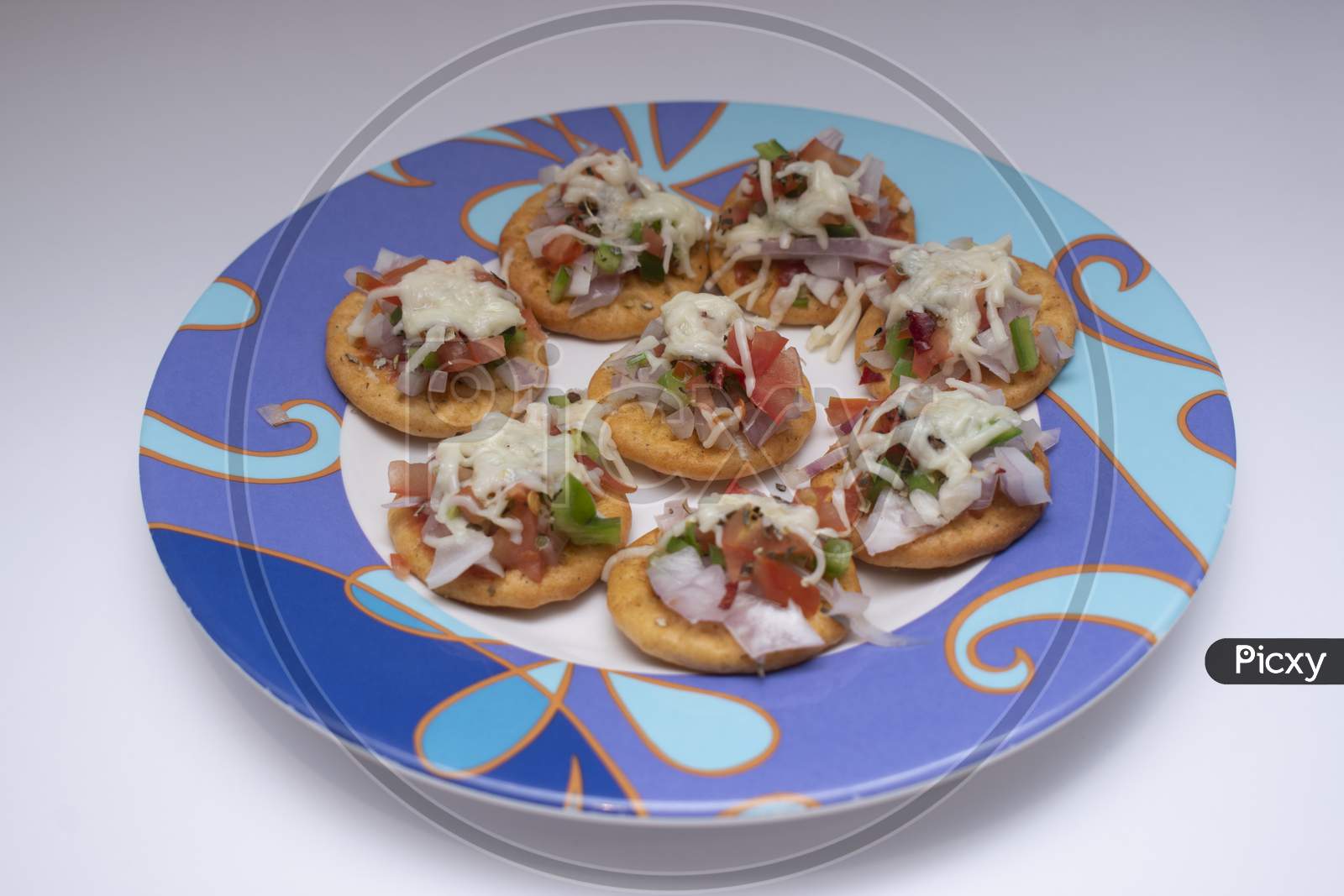 Moncao Biscuit Cheese Pizza In A Round Dish With Cheese And Vegetable Toppings On It