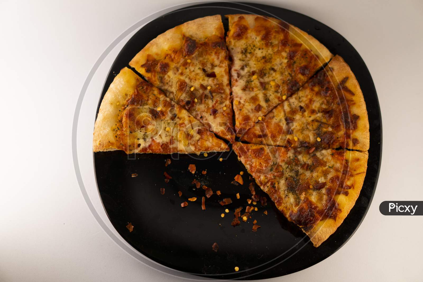 Pizza on a black plate against a white  background .
