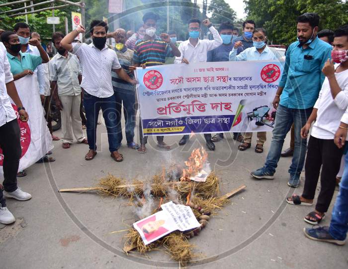 Members of All Assam Students Union(Aasu) burn effigies of Union Petroleum Minister Dharmendra Pradhan and Assam Food and Civil Supplies Minister Phani Bhusan Choudhury to protest against the hike in prices of fuel and essential commodities in Nagaon, Assam on July 03, 2020.