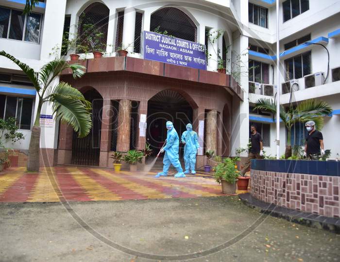 Firefighters wearing hazmat suits spray disinfectant in judicial courts after reports of five staff members who tested positive for Coronavirus in Nagaon, Assam on July 03, 2020.