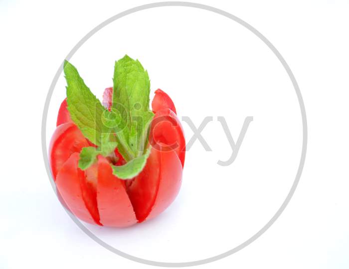 the red ripe tomato with green mint leaf isolated on white background.