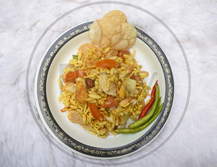 Top View Of Bhel Puri Dish, A Popular Indian Street Snack Chat, Served With Papdi Chaat And Green Spicy Chilly. Bhel Made Of Puffed Rice, Chopped Tomatoes, Onions
