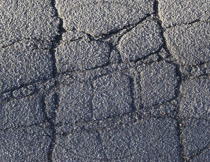 Detailed view on asphalt surfaces of different streets and roads with cracks