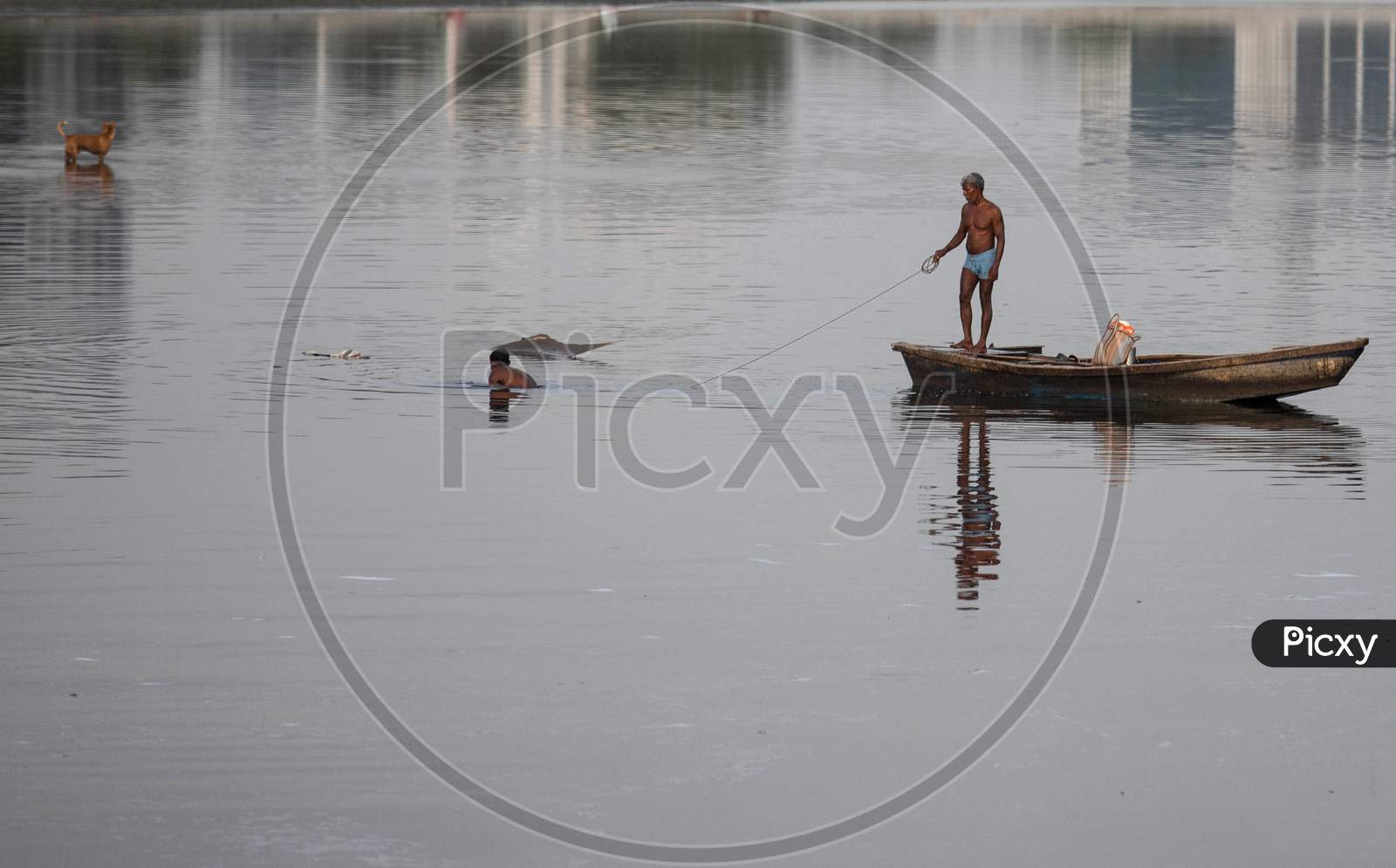 Indian Fishermen Use A Fishing Net In The Polluted Water Of The Yamuna River On July 30, 2020 In New Delhi, India.