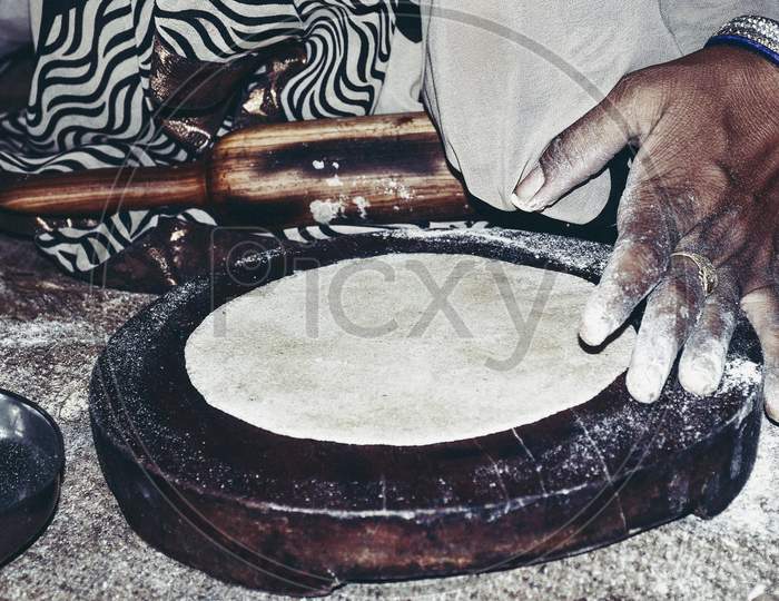 Indian Women Handling Bread With Indian Cylinder Of Wood