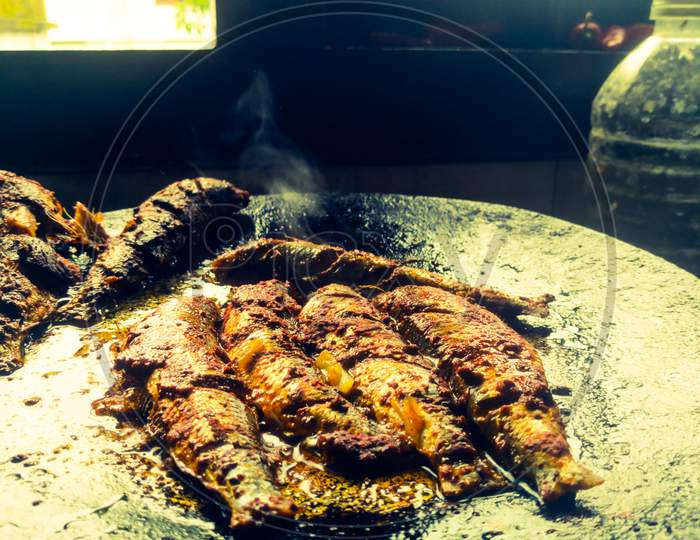 A Long Shot Of Sardine Fish Frying In A Pan In Kerala Style.