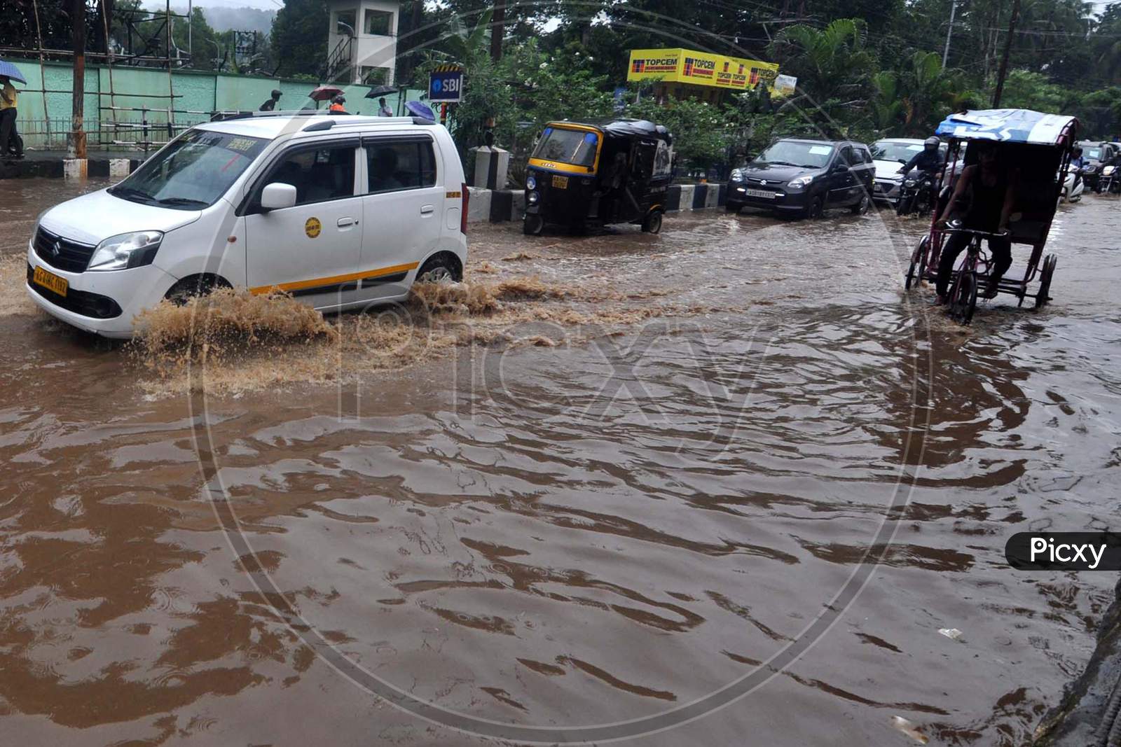 Commuters Wade Through A Waterlogged Street After Heavy Rainfall  In Guwahati On July 30, 2020.