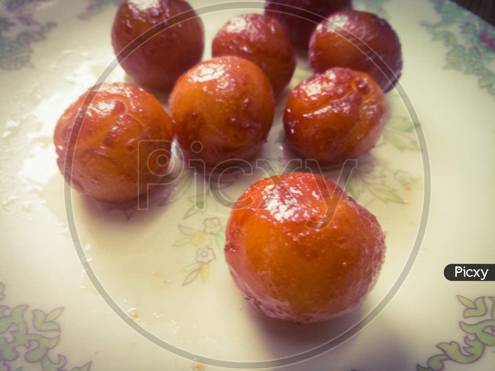 Gulab Jamun Balls With Sugar Syrup Placed In A White Plate.