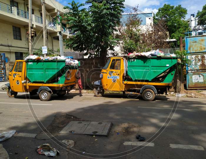 Closeup of Garbage Collecting Green and Yellow Color Auto parking on Roadside