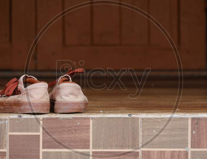 Student Old Brown Standard Sneakers On The Wooden Floor