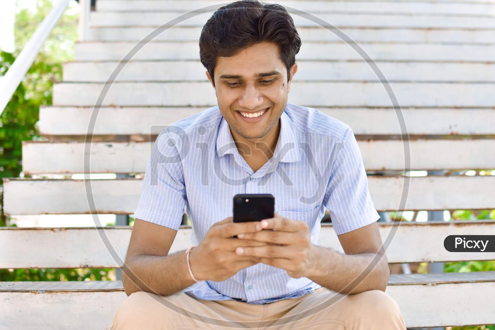 indian college student playing mobile phone