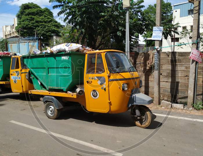 Closeup Of Garbage Collecting Green And Yellow Color Auto Parking On Roadside