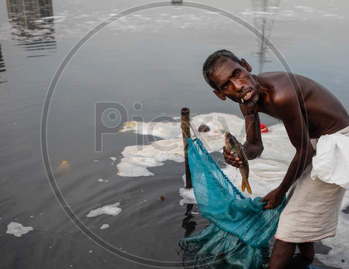 An Indian man Fishes In The Polluted Waters Of The Yamuna River On July 30, 2020 In New Delhi, India.