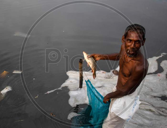 An Indian man fishes In The Polluted Water Of The Yamuna River On July 30, 2020 In New Delhi, India.
