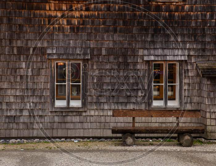 old wooden facade house exterior with park bench