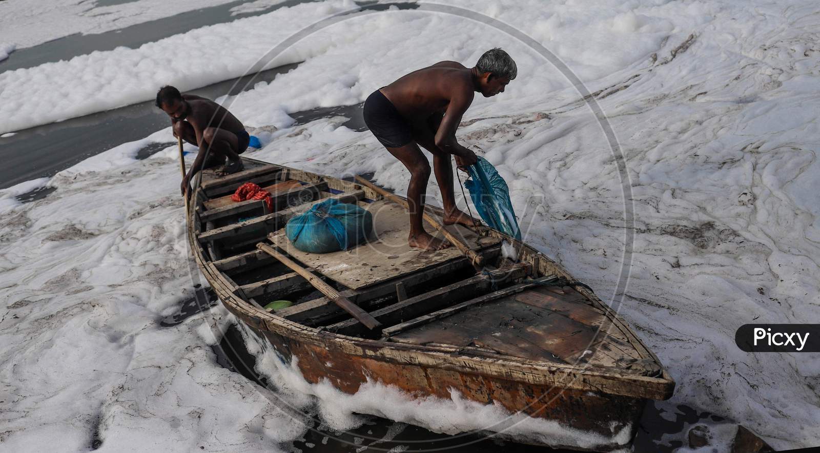 Indian Fishermen Use A Fishing Net In The Polluted Waters Of The Yamuna River On July 30, 2020 In New Delhi, India.