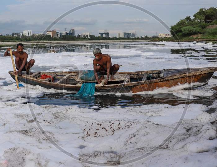 Indian Fishermen Use A Fishing Net In The Polluted Waters Of The Yamuna River On July 30, 2020 In New Delhi, India.