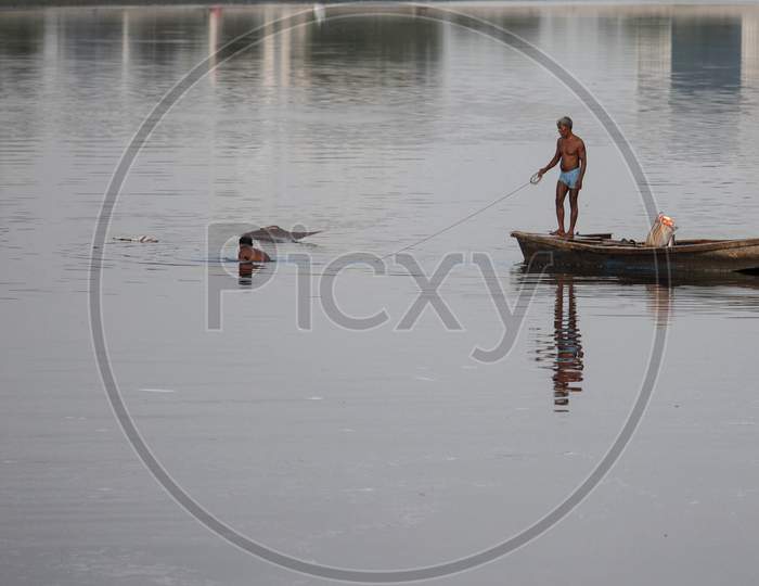 Indian Fishermen Use A Fishing Net In The Polluted Water Of The Yamuna River On July 30, 2020 In New Delhi, India.
