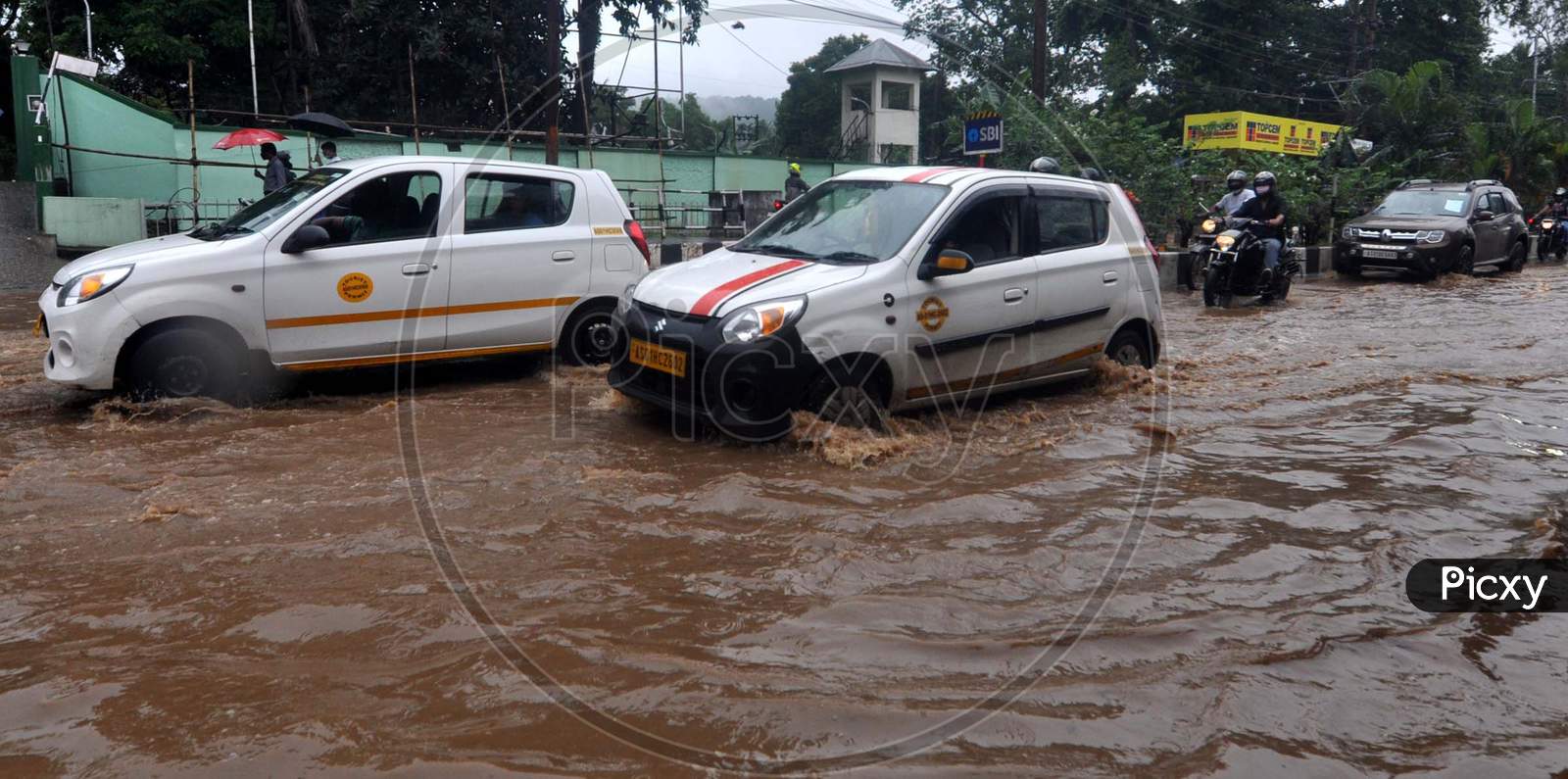 Commuters Wade Through A Waterlogged Street After Rainfall  In Guwahati On July 30, 2020.