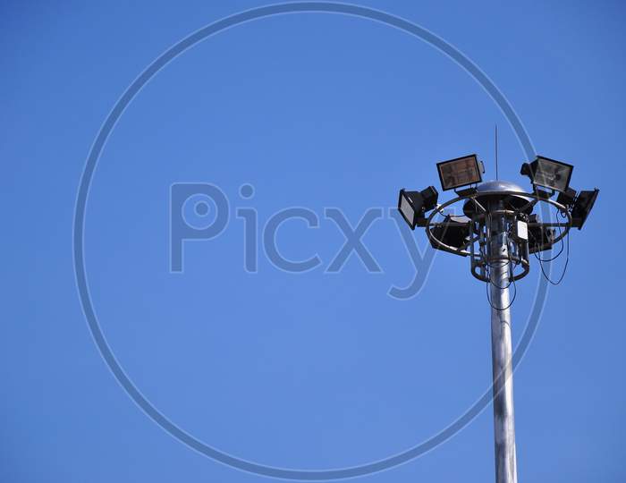 Bunch Of Spotlight Lamps On Top Of The Metal Post With Bright Blue Sky, Copy Space For Insert