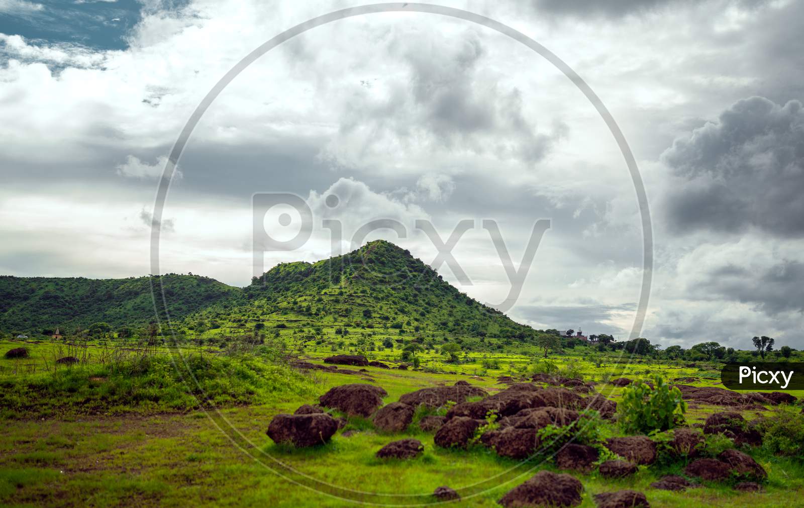 Green hill cloudy sky landscape image