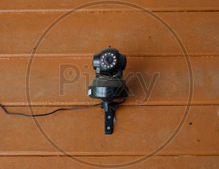 Dusty Black Cctv Security Ip Camera On Wooden Wall