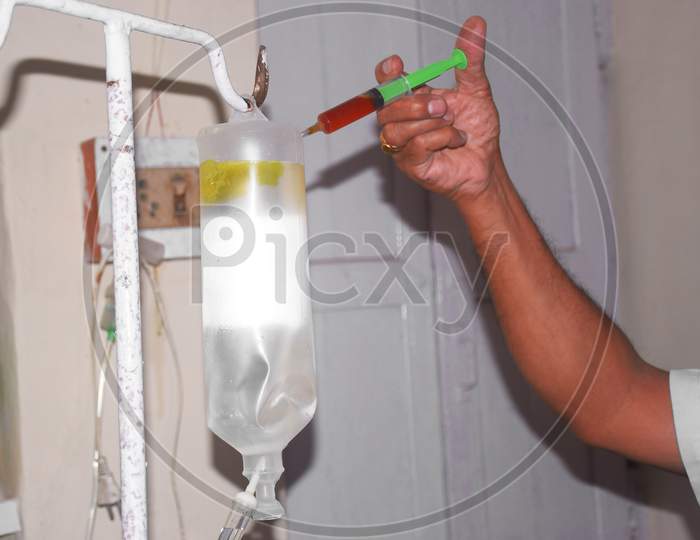 Pouring The Medicine Into The Bottle With A Syringe, Doctor'S Hand Holds A Syringe And A Infusion Bottle At The Hospital. Health And Medical Concepts