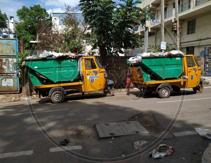 Closeup of Garbage Collecting Green and Yellow Color Auto parking on Roadside
