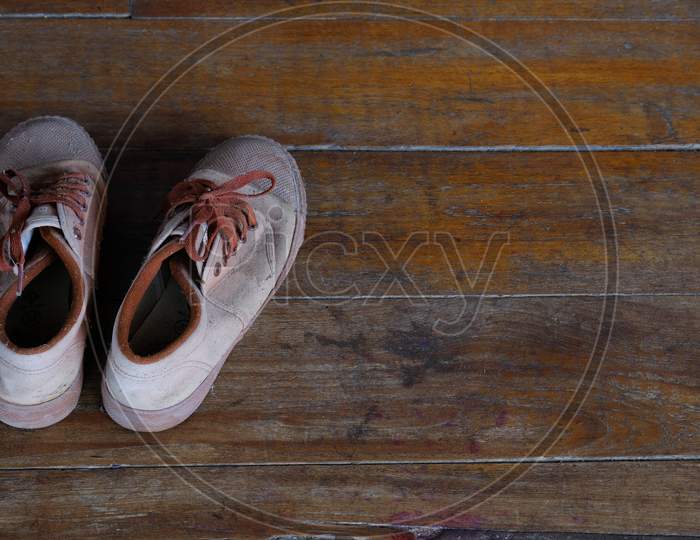 Student Old Brown Standard Sneakers On The Wooden Floor