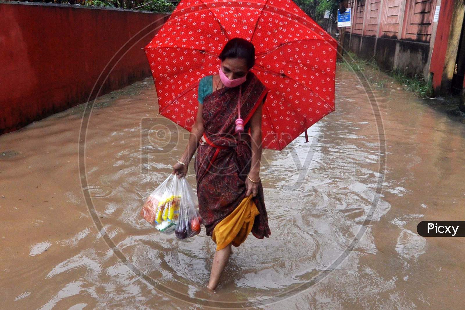 A Woman Wades Through A Waterlogged Street After Rains  In Guwahati On July 30,2020