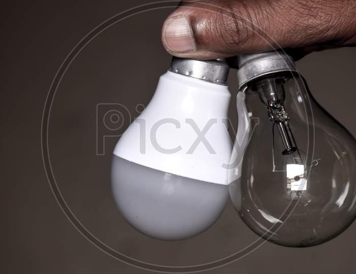 Led And Fluorescent Bulb Comparing In Hand For Alternative Technology Concept