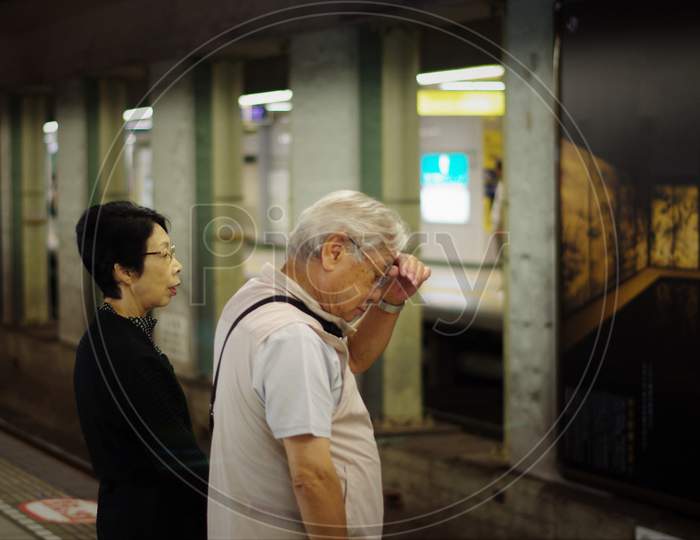 Shanghai - July 21 2020: Two Middle-Aged Lung Passengers Who Are Patiently Waiting For The Subway To Arrive. Standing On The Edge Of The Train Entrance. Safe Lines Have Been Provided To Wait So That They Are Not Dangerous When The Train Comes.