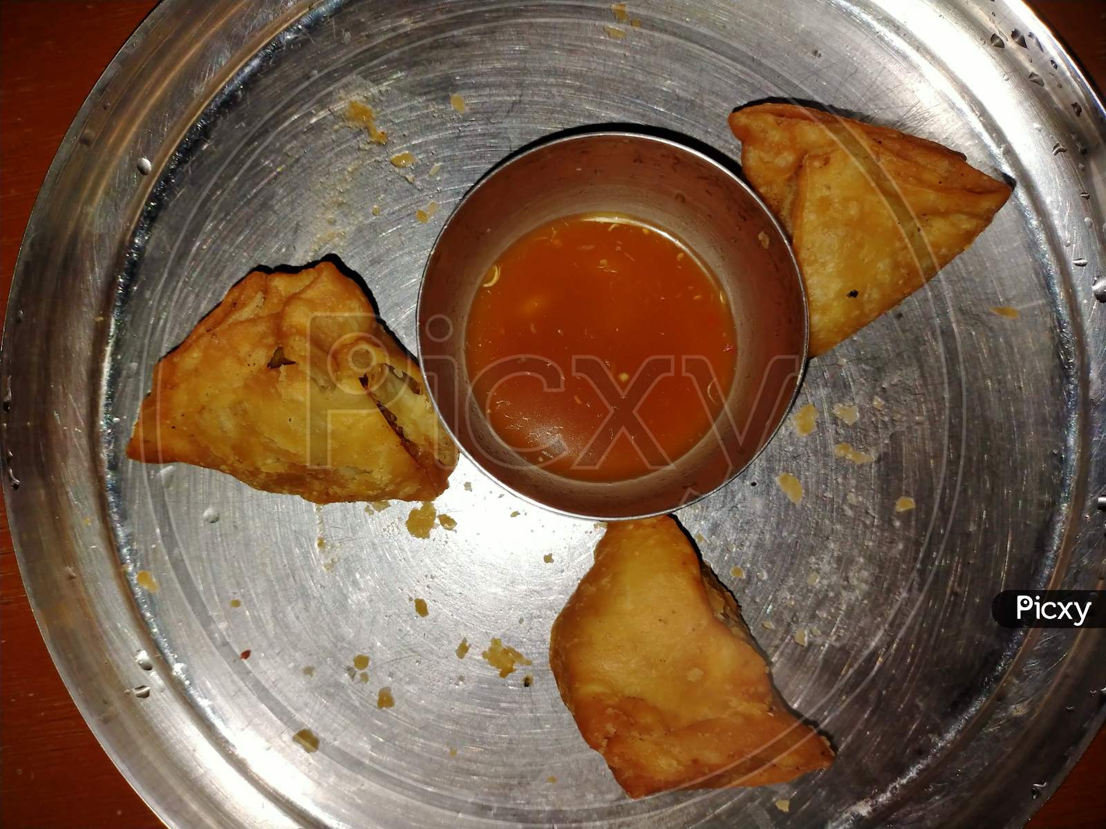 Samosa and chutney in a plate with black and grey background
