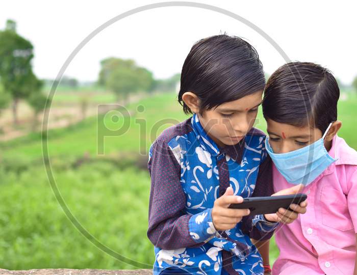 indian kids playing with mobile phone